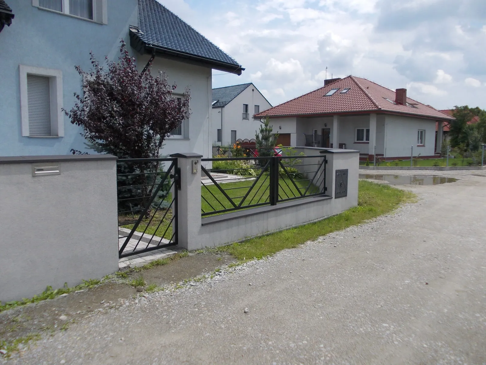 Nowoczesne ogrodzenie antracytowe z ukośnym wzorem i furtką przy domu
